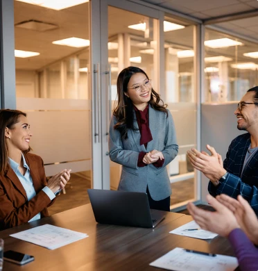 Une équipe applaudit une collaboratrice lors d’une réunion d’accompagnement en entreprise